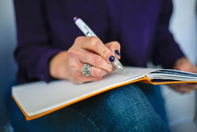 Hands writing in a notebook